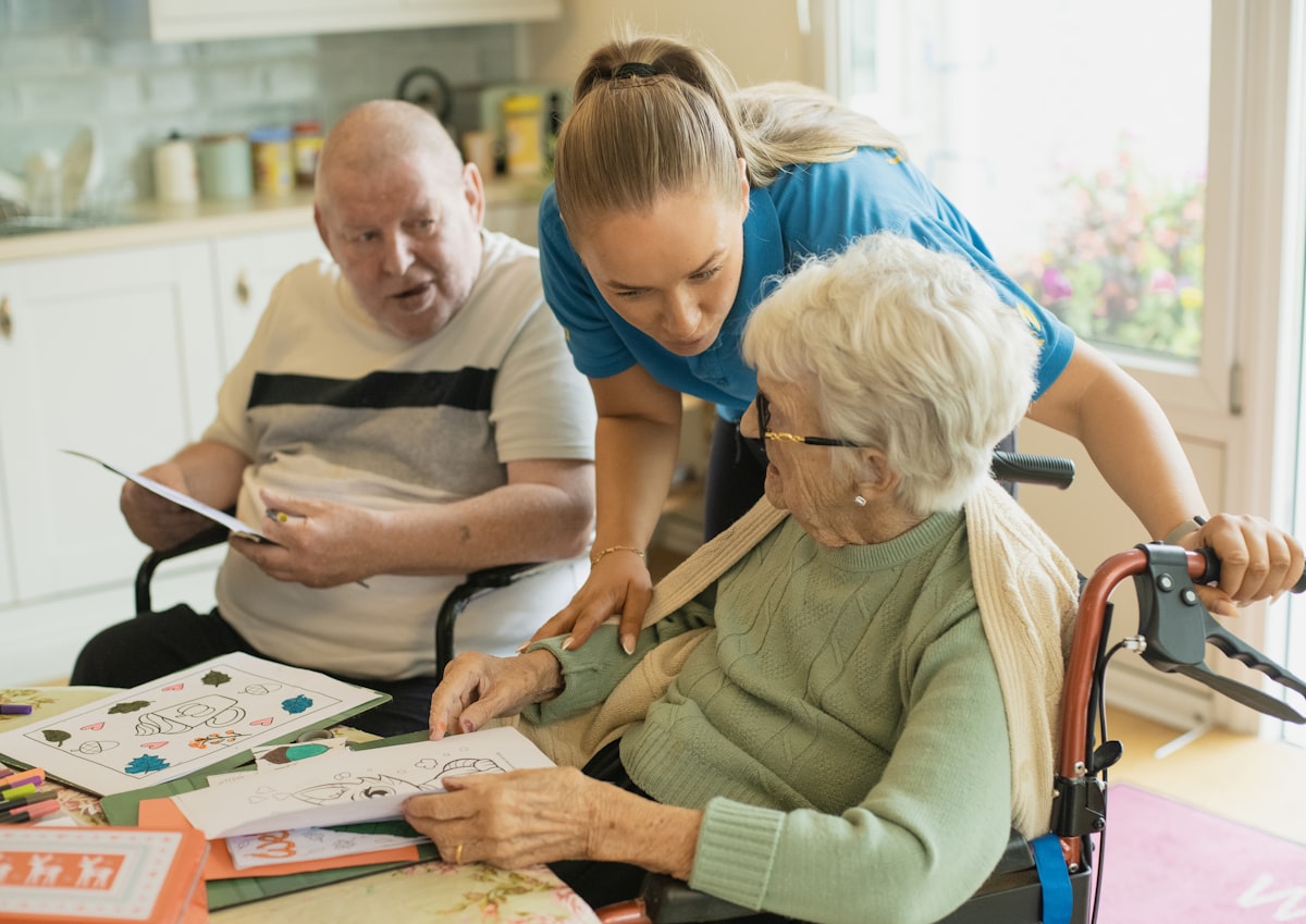 A caregiver spending time with an elderly couple at home